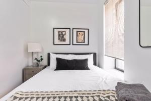 Lovely 3 bedroom apartment in NYC 2 في نيويورك: غرفة نوم بيضاء مع سرير أبيض كبير ونافذة