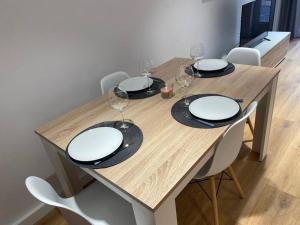 una mesa de madera con platos y copas de vino. en Apartamento Playa Levante, en Santa Pola
