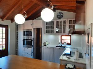 una cucina con mobili bianchi e un frigorifero nero di Casa da Eira de Cima a Chão Sobral