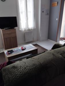 1 dormitorio con cama, mesa y TV en Maison classée 2 étoiles en plein cœur de Margaux en Margaux