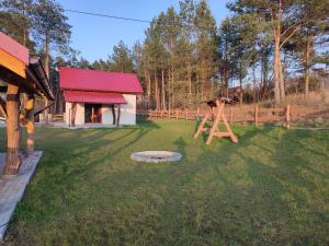 a yard with a play structure and a house at Domek pod sosnami in Gaj