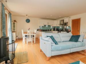 a living room with a couch and a kitchen at Kestrel, 19 Dartmouth Green in Totnes