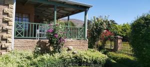 a house with a porch with flowers on it at Clarens Mount Rose self-catering holiday house in Clarens