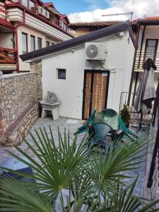 ein kleines weißes Haus mit einer Terrasse und einem Tisch in der Unterkunft Old Town Patio House in Ohrid