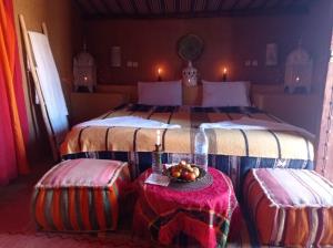 - une chambre avec un grand lit et 2 ottomanes dans l'établissement Rêves de désert, à M'Hamid El Ghizlane