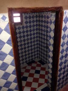 a bathroom with a tiled floor and a mirror at Rêves de désert in Mhamid