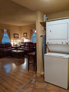 a living room with a white refrigerator in a room at Third Mission Heritage Suites in Peace River