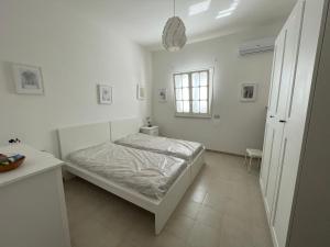 a white bedroom with a bed and a window at Villa Tonia in San Pietro in Bevagna