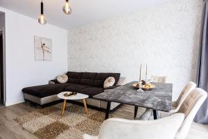 sala de estar con sofá y mesa en Vanilla Apartment - Pipera en Bucarest