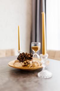un plato de comida y una copa de vino en una mesa en Vanilla Apartment - Pipera en Bucarest