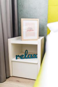 a picture frame sitting on top of a white shelf at Vanilla Apartment - Pipera in Bucharest