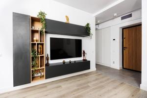 a living room with a flat screen tv on a wall at Vanilla Apartment - Pipera in Bucharest