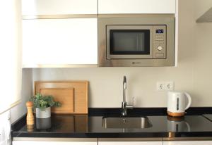 una cocina con fregadero y microondas en Casa La Victoria, en Málaga