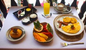 einen Tisch mit Teller mit Lebensmitteln auf einem Tisch in der Unterkunft Casa de Alba Hotel Boutique in Cartagena de Indias