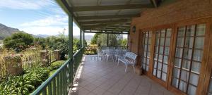 a patio with tables and chairs on a balcony at Clarens Mount Rose self-catering holiday house in Clarens