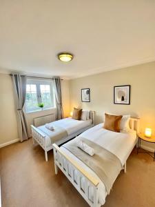 a bedroom with two beds and a window at 2 Bed Serviced Apartment with Balcony, Free Parking, Wifi & Netflix in Basingstoke in Basingstoke