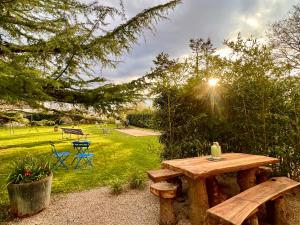 una mesa de picnic de madera y sillas en un jardín en GSand Le Clos du May, en Le Poinçonnet