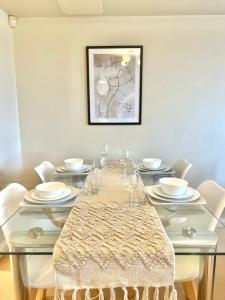 a dining room with a glass table and white chairs at 2 Bed Serviced Apartment with Balcony, Free Parking, Wifi & Netflix in Basingstoke in Basingstoke