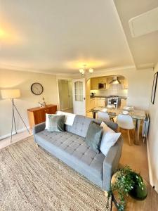uma sala de estar com um sofá e uma cozinha em 2 Bed Serviced Apartment with Balcony, Free Parking, Wifi & Netflix in Basingstoke em Basingstoke