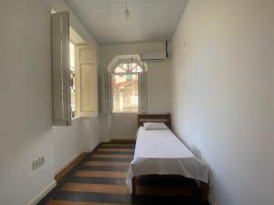 a small room with a bed in a room with a window at Sunflower Hostel in Salvador