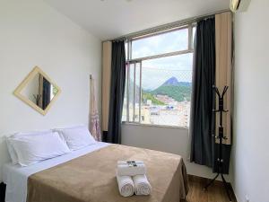 - une chambre avec un lit et une grande fenêtre dans l'établissement AD12 - Apto a 4 min da praia - vista pro Cristo, à Rio de Janeiro