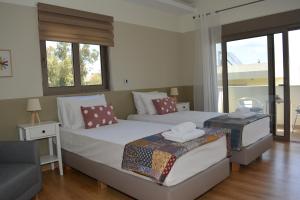 - une chambre avec 2 lits, un canapé et des fenêtres dans l'établissement Home21, à Asgourou