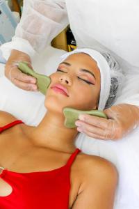 a woman laying on a bed with a mask on her face at Pousada Kairos & Spa em Búzios in Búzios