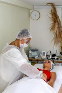 una enfermera que prepara a un niño en una cama de hospital en Pousada Kairos & Spa em Búzios, en Búzios