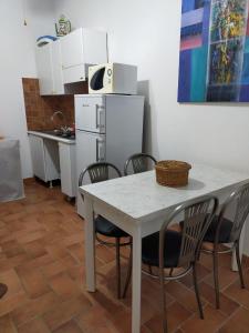 a kitchen with a white table and chairs and a refrigerator at Guarda che Luna Apartment in Porto Empedocle