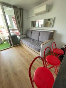 een woonkamer met een bank en rode stoelen bij alcossebrerelax in Alcossebre