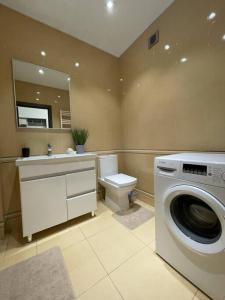 y baño con lavadora y aseo. en Sky House Premium apartment in City Center, en Chişinău