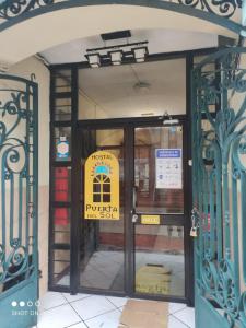 une entrée à un bâtiment avec un panneau sur la porte dans l'établissement Hostal puerta del sol, à Quito