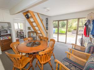une salle à manger avec une table et des chaises en bois dans l'établissement Pihanga Cottage - Kuratau Bach, à Kuratau