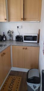 a kitchen with a microwave on top of a counter at Once Upon a Tide - Bridlington Chalet in Bessingby