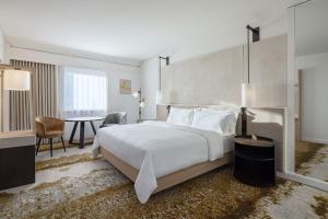 a bedroom with a large white bed and a table at The Westin Grand Frankfurt in Frankfurt/Main