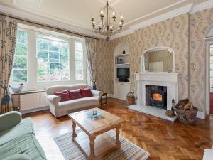 uma sala de estar com um sofá e uma lareira em Lumsdale House em Matlock