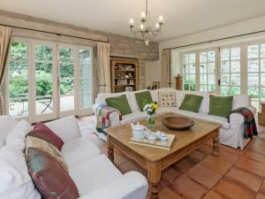uma sala de estar com sofás brancos e uma mesa em Lumsdale House em Matlock