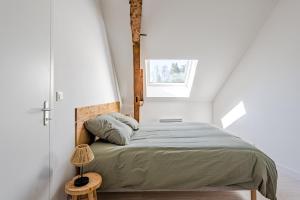 a bedroom with a large bed with a window at L’orne in Caen