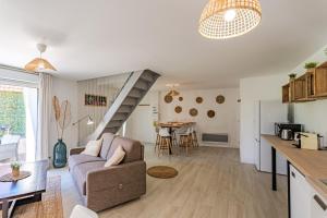 a living room with a couch and a dining room at L’orne in Caen