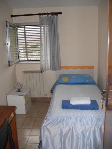 a bedroom with a bed with blue sheets and a window at Casa Vacanze da Sina in Linguaglossa