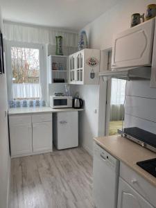 kuchnia z białymi szafkami i białymi urządzeniami w obiekcie Mieszkanie 2 pok 2 min do morza w mieście Sopot