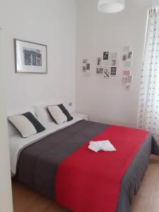 a bedroom with a large bed with a red blanket at Hotel Migani in Rimini