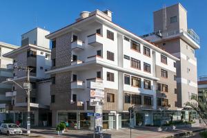 a large white building on the corner of a street at Mar de Canasvieiras Hotel e Eventos in Florianópolis