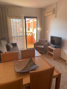 a living room with a table and a television at Apartment Punta Umbría Luxury in Punta Umbría