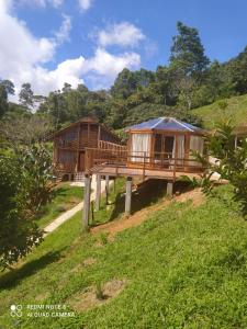 Deux cabanes sur une colline avec des arbres dans l'établissement Reserva Natural Cascadas de Padilla, à Lérida