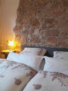 two beds with pillows in front of a stone wall at Ferienwohnung Höfenhof in Schiltach
