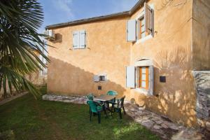 una mesa y sillas frente a una casa en Holiday Home Marta, en Žminj