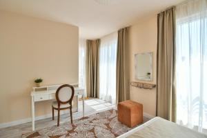 Habitación de hotel con escritorio y silla en Chaika 203 en Varna