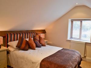 a bedroom with a bed with pillows and a window at Fenn House in Alvechurch