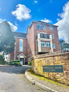 a brick building with a sign in front of it at 2 Bed Serviced Apartment with Balcony, Free Parking, Wifi & Netflix in Basingstoke in Basingstoke